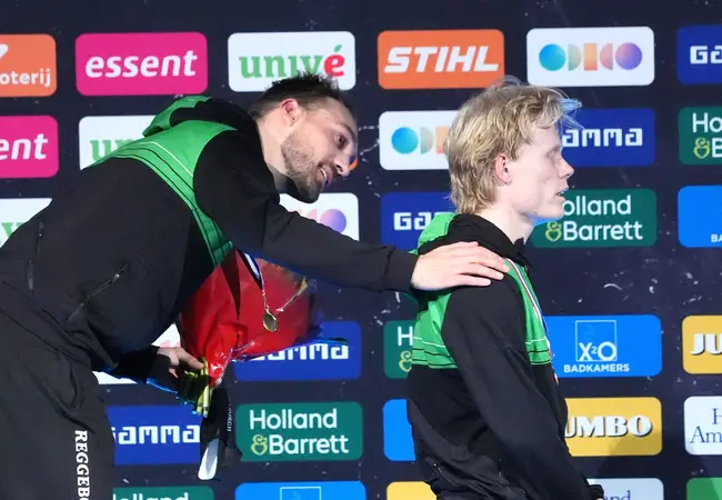 Kjeld Nuis steunt Tim Prins tijdens het Wilhelmus