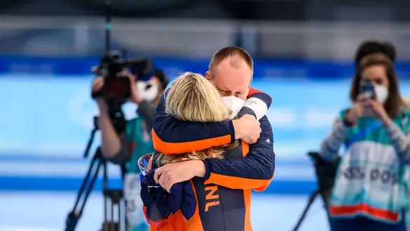 Erik Wink geeft een knuffel aan Irene Schouten na de 5 kilometer